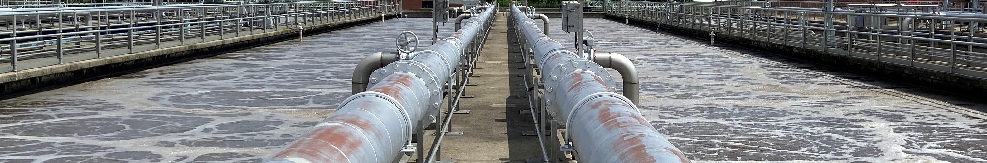 Wastewater reservoir and pipes at a wastewater treatment plant.