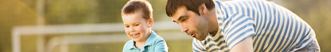 Father and young son playing soccer