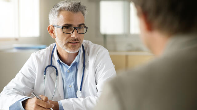 A doctor talking to a patient in his office