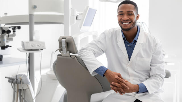Smiling dentist in their office