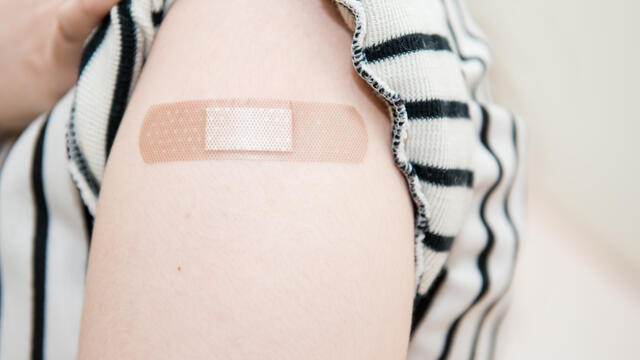 Close up of a bandage on arm after a receiving vaccinated