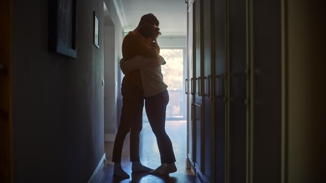 Adults providing comfort with a hug