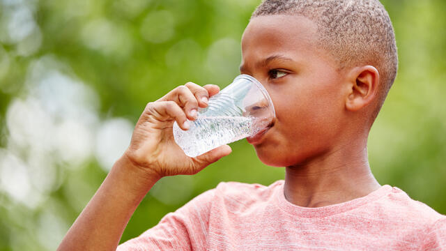 Close up of a child drinking a glass of water