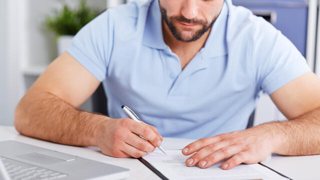 Adult signs a document