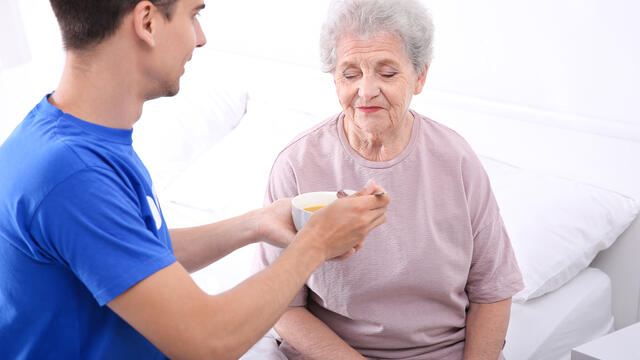 A caregiver assisting an older adult during meal time