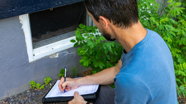 Building inspector checking basement windows
