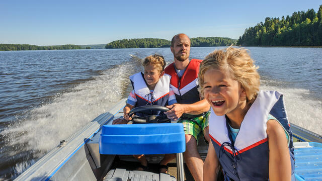 Adult with two children enjoying boating