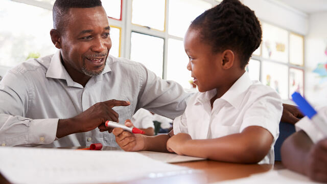 Teacher helping at student
