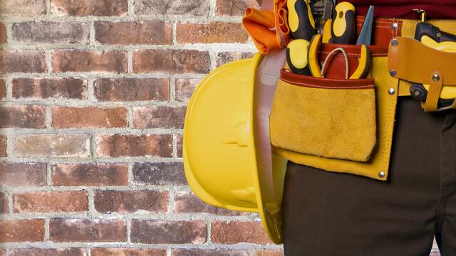A tool apron with tools and a hard hat.