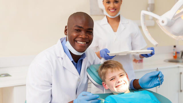 Smiling dentist, assistant and child
