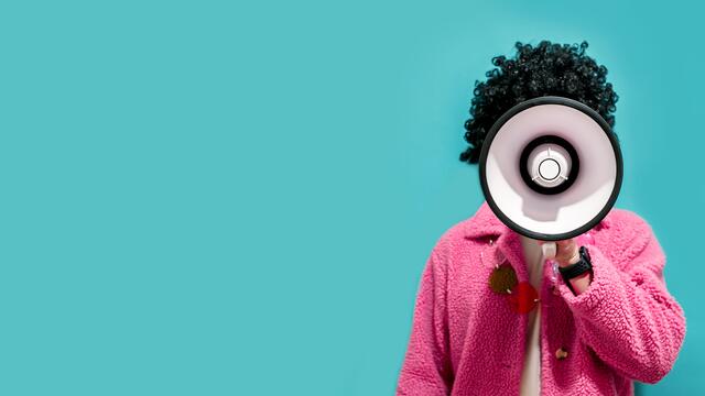 Person using a megaphone against an aqua background