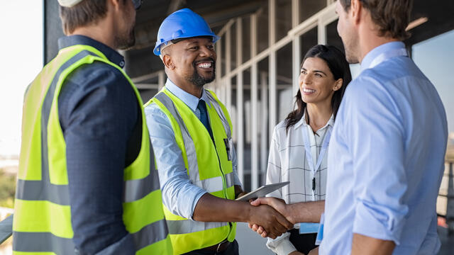 Contractors shake hands with business professionals