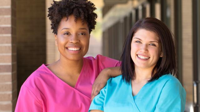 Two nurses standing outside a health center