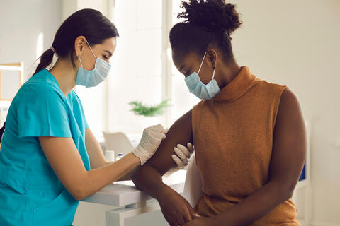 Medical staff vaccinating an adult