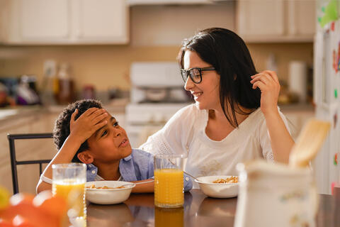 Adult and child eating breakfast in the kitchen