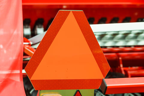 Slow moving vehicle sign, red triangle sign with orange triangle in the middle