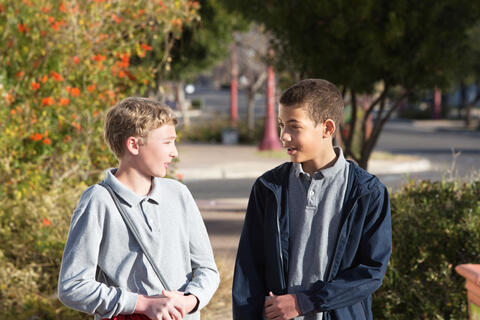 Two teens talking outdoors