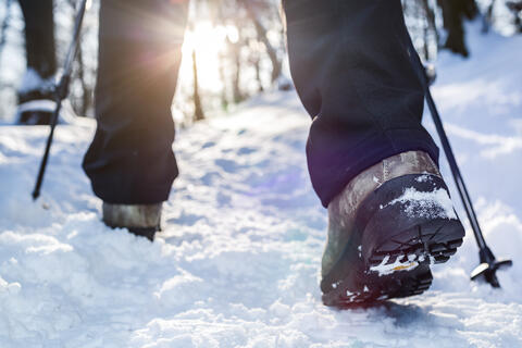 A pair of winter hiking boots walking on the snow
