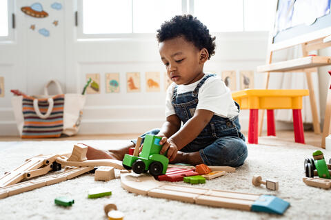 A child sitting on the floor playing with toys