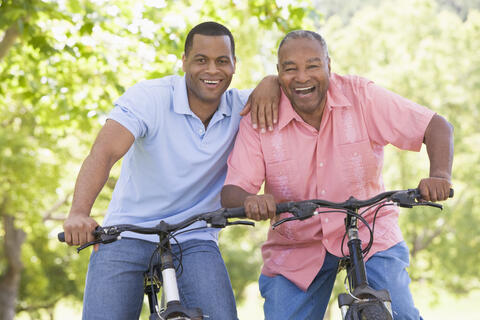 Two happy adults on their bicycles in the park