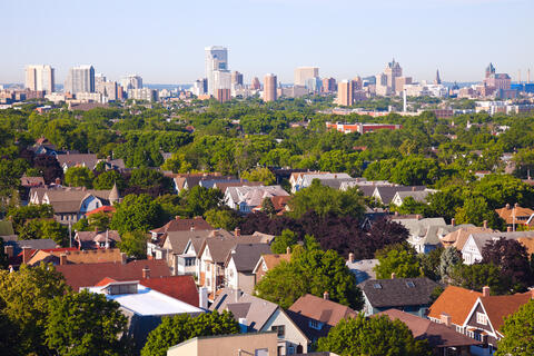 Looking over the neighborhood homes with trees and downtown buildings in the background, Milwaukee