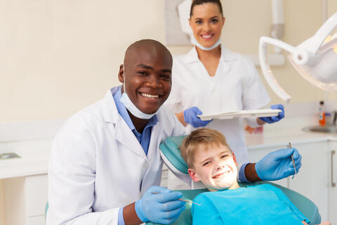 Smiling dentist, assistant and child