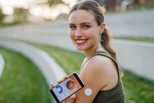 Adults checks glucose on a smart phone app