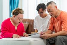 Adult helps two teens with homework