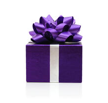 Box wrapped in purple paper with silver ribbon and a purple bow
