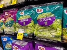 Row of bagged lettuce in a grocery store