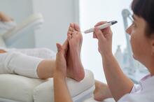 Doctor using a diabetic foot probe on a patient