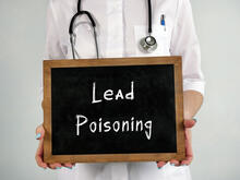 Doctor holding a lead poisoning sign