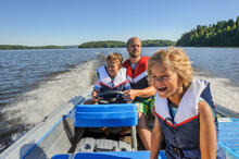 Adult with two children enjoying boating