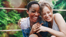 Smiling young adult friends hugging