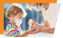 COVID-19 adult pouring hand sanitizer in a child's hand