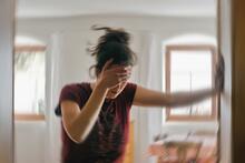 Adult with vertigo holds onto wall to steady themself