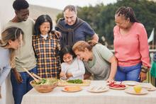 Seven family members around a table of food outside