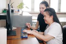 Two smiling coworkers using a braille computer
