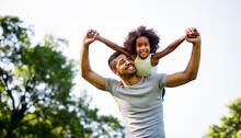 Smiling adult with smiling child on back