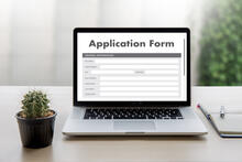 Application form on a laptop with a small cactus plant next to it