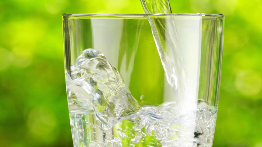 Glass being filled against outdoor background