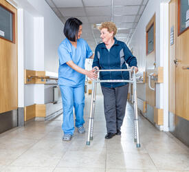 Nurse assisting a senior adult using a walker